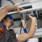 Technician repairing a garage door for Expert Garage Doors.