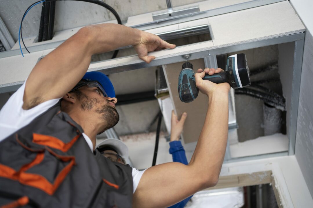 Technician repairing a garage door for Expert Garage Doors.