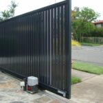 Black gate with motor installed by Expert Garage Doors for automation.