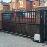 Black gate with motor for automatic operation, installed by Expert Garage Doors.