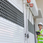 Woman inspecting roller shutter doors installed by Expert Garage Doors.