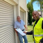 Expert Garage Doors technician consulting with happy homeowner about garage door installation.