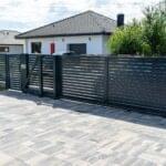 Black gate installed by Expert Garage Doors, ensuring secure access control.