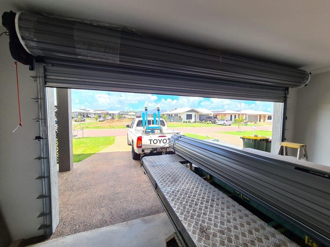 Bakkie towing a trailer near roller shutter doors installed by Expert Garage Doors.