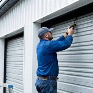 Technician repairing roller shutter doors for Expert Garage Doors.